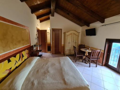 a bedroom with a large bed and a table with chairs at Cilento Antico in Stella Cilento