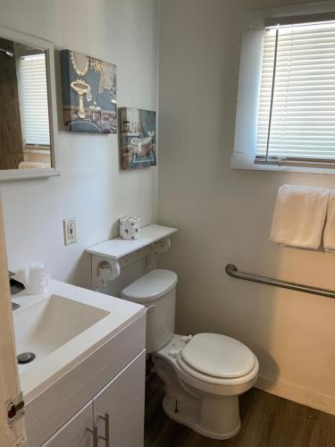 a white bathroom with a toilet and a sink at Americas Best Value Inn Royal Carriage in Jamestown