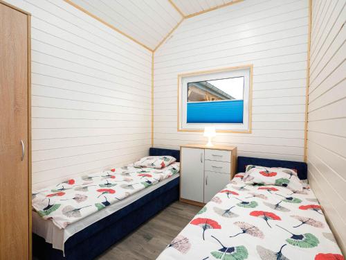 - une chambre avec 2 lits et une fenêtre dans l'établissement Cottages, 500m to the lake, Jezierzany, à Jezierzany
