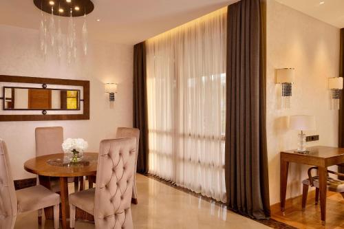 a dining room with a table and chairs and a window at Parklane, a Luxury Collection Resort & Spa, Limassol in Limassol