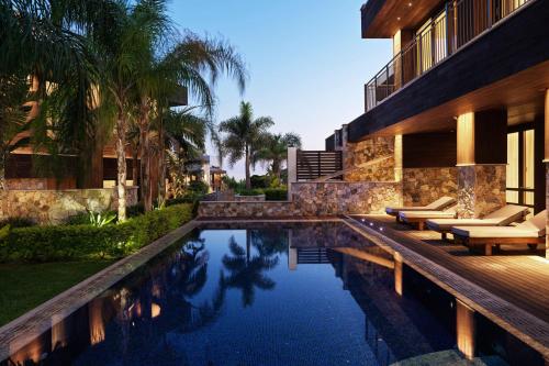 une maison avec une piscine à côté d'un bâtiment dans l'établissement Parklane, a Luxury Collection Resort & Spa, Limassol, à Limassol