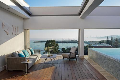 a living room with a couch and a swimming pool at Parklane, a Luxury Collection Resort & Spa, Limassol in Limassol