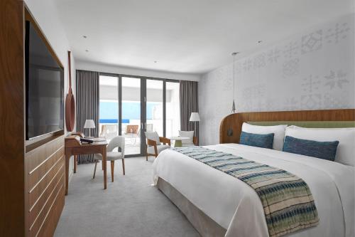 a hotel room with a large bed and a desk at Parklane, a Luxury Collection Resort & Spa, Limassol in Limassol