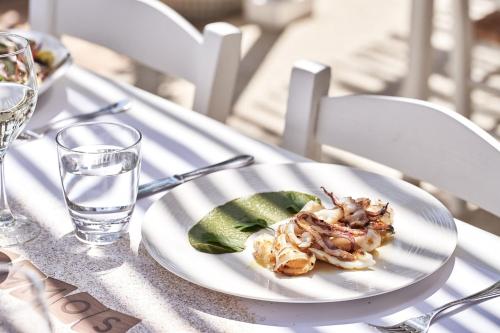 a plate of food on a table with a glass of water at Parklane, a Luxury Collection Resort & Spa, Limassol in Limassol