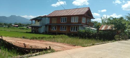 una casa sentada al lado de un camino de tierra en Purabarang Homestay en Rantepao