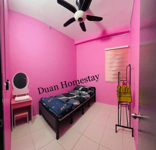 a pink room with a bed and a ceiling fan at Duan Homestay @ Cybersouth (Muslim shj) in Kampung Dengkil