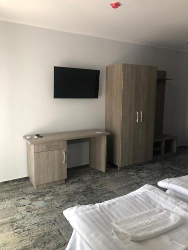 a bedroom with a desk and a tv on the wall at Sub Cetate in Râşnov