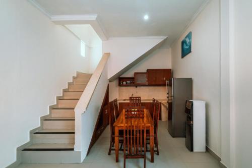a dining room with a table and a staircase at Umah Kita in Seminyak