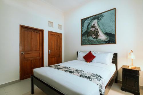 a bedroom with a bed and a picture on the wall at Umah Kita in Seminyak