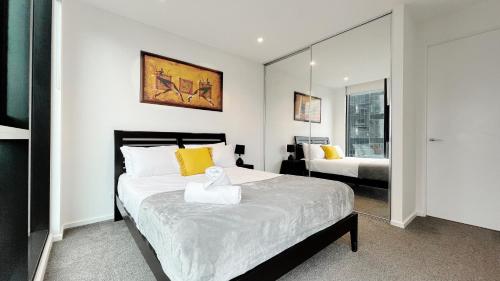 メルボルンにあるMelbourne One 2B2B1C Apartment by GoodLiveのベッドルーム(大型ベッド1台、鏡付)