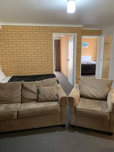 a living room with a couch and a bed at Port Campbell Parkview Motel & Apartments in Port Campbell