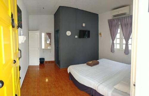 a bedroom with a white bed and a black wall at Vagary Pangkor in Pangkor