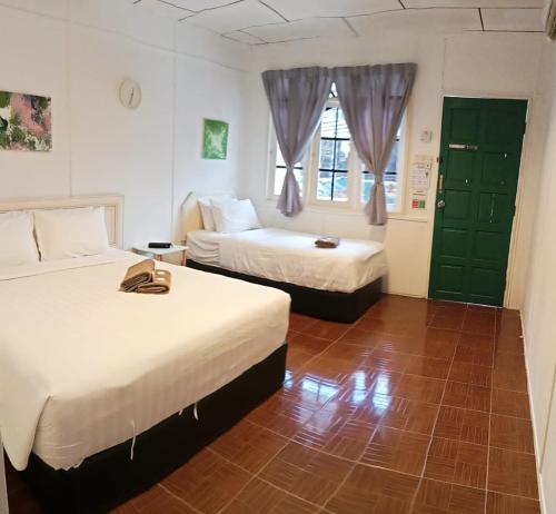 a hotel room with two beds and a window at Vagary Pangkor in Pangkor
