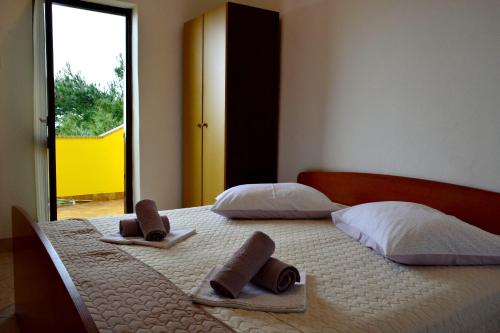 een slaapkamer met 2 bedden en handdoeken bij Apartment Maris - next to the beach in Lukovo Šugarje