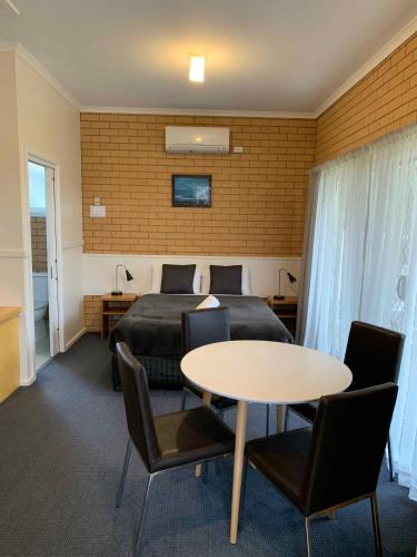 a room with a bed and a table and chairs at Port Campbell Parkview Motel & Apartments in Port Campbell