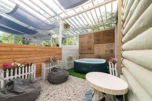 a greenhouse in a garden with a bench and a table at Inn OZZ in Karagandy