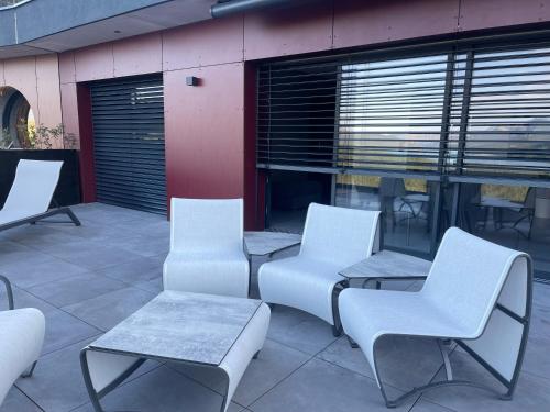 a group of chairs and tables on a patio at Les Restanques du lac in La Chapelle