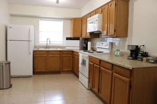 a kitchen with wooden cabinets and white appliances at Hidden Emerald-Apartment with Kitchen and Laundry in Lakeland