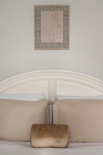un letto bianco con testiera bianca e una foto sul muro di Hidden Emerald-Apartment with Kitchen and Laundry a Lakeland