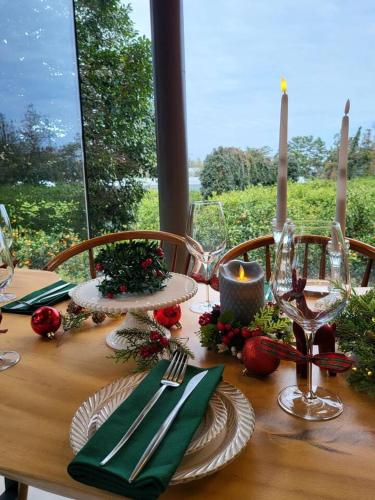 a wooden table with plates and wine glasses on it at U.G.SODAM (Uigwisodam) in Seogwipo