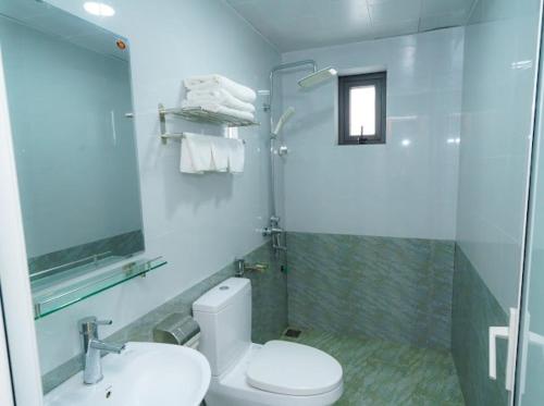 uma casa de banho com um WC, um chuveiro e um lavatório. em Kim Ngan Ha Long Hotel em Ha Long