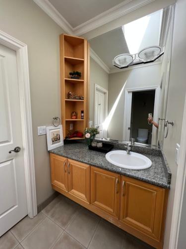 a bathroom with a sink and a mirror at A cozy bedroom with a private washroom close to YVR Richmond in Richmond