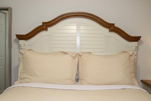 łóżko z drewnianym zagłówkiem i 2 poduszkami w obiekcie Hidden Ruby-Apartment with Kitchen and Laundry w mieście Lakeland