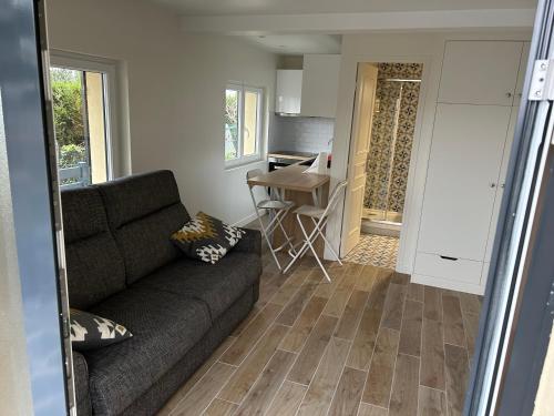 ein Wohnzimmer mit einem Sofa und einer Küche in der Unterkunft House with a fantastic panoramic view in Le Pecq