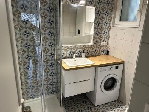 ein Badezimmer mit einem Waschbecken und einer Waschmaschine in der Unterkunft House with a fantastic panoramic view in Le Pecq