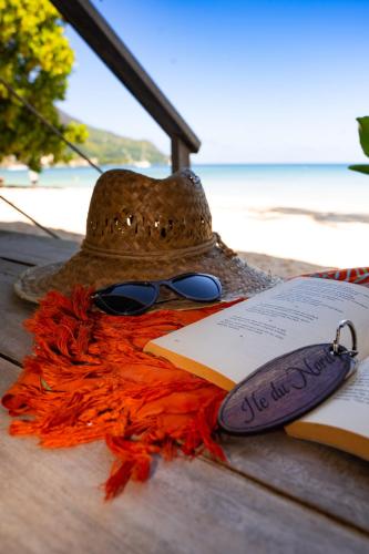 a hat and a book on a table with a book at Clef des Iles in Beau Vallon