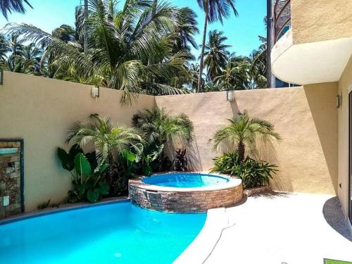 a swimming pool in a backyard with palm trees at Villa De Santos Acapulco Playa Bonfil Alberca in Acapulco