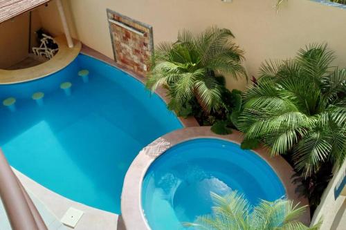 a pool in a house with palm trees in it at Villa De Santos Acapulco Playa Bonfil Alberca in Acapulco