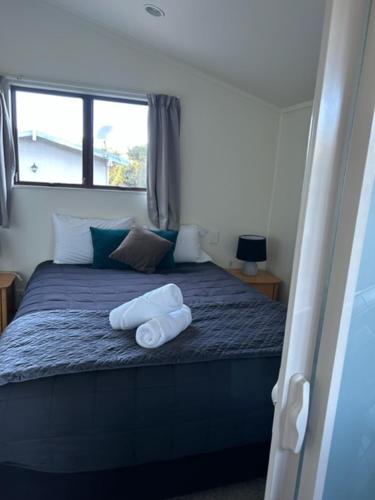 a bedroom with a bed with two towels on it at Russell Top 10 Holiday Villas in Russell