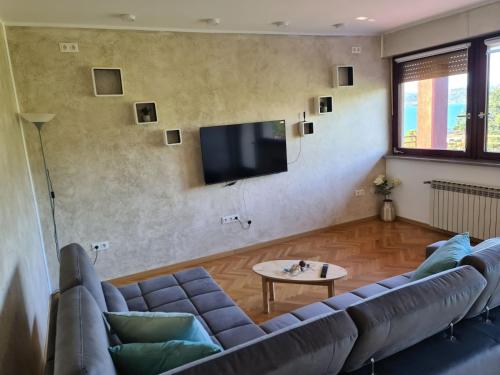 een woonkamer met een bank en een flatscreen-tv bij Amore Koper in Koper