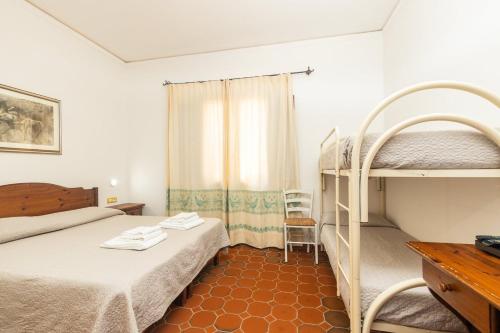 a bedroom with two bunk beds and a desk at Hotel L'Ulivo in Girasole