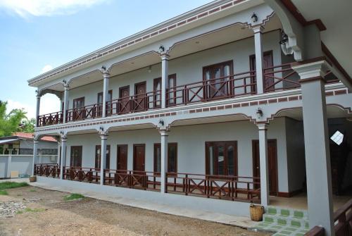 an external view of a building with balconies at Mama Leurth Sunset Guesthouse in Don Det