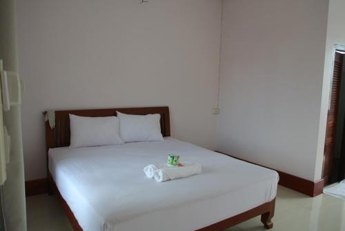 a white bed with a stuffed animal on top of it at Mama Leurth Sunset Guesthouse in Don Det