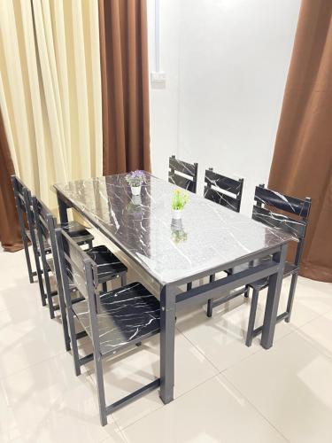 mesa de comedor con sillas y encimera de cristal en Homestay Azirah-musleem preferred, en Pekan