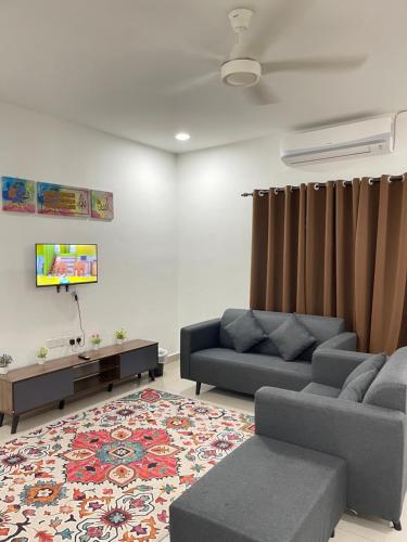 sala de estar con 2 sofás y TV en Homestay Azirah-musleem preferred, en Pekan
