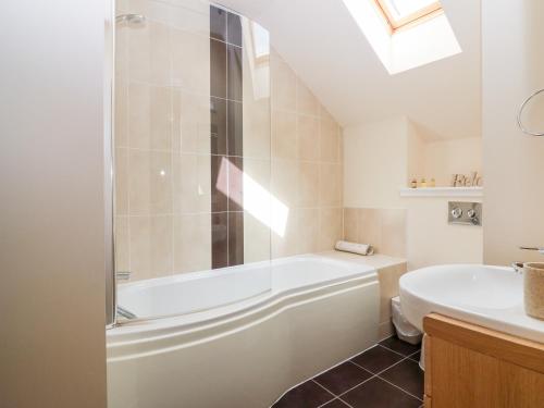 uma casa de banho com uma banheira e um lavatório em Glebe Cottage Number 6 em St Andrews