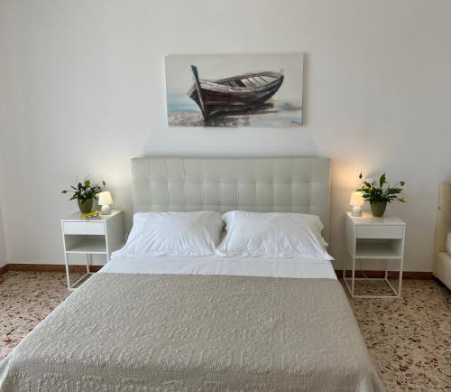 1 dormitorio con 1 cama y 1 barco en la pared en Domusvacanza Salento, en Santa Caterina di Nardò