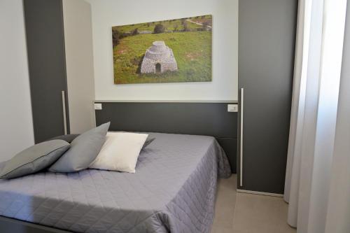 a bedroom with a bed and a painting on the wall at Altamarea Beach Experience Villetta SA in Marina di Pescoluse