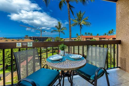 una mesa y sillas en un balcón con vistas al océano en Maui Vista 3411 condo, en Kihei