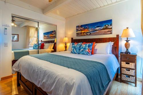 1 dormitorio con 1 cama grande y espejo en Maui Vista 3411 condo, en Kihei