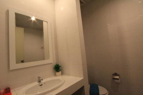 a bathroom with a sink and a mirror and a toilet at Sleep Easy in Kata Beach