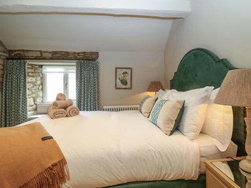 a bedroom with a large bed with teddy bears on it at Spinners Cottage in Stow on the Wold