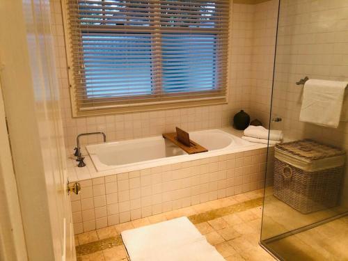 baño con bañera con ventana y ventana en Lenore at Armidale en Armidale