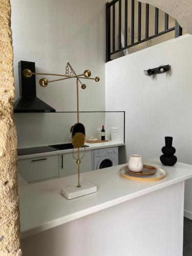 une cuisine avec un comptoir blanc, une plaque de cuisson et une horloge dans l'établissement Domain de Montvert - 5 min from Saint Emilion, à Sainte-Terre