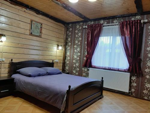 a bedroom with a bed and a window with curtains at Zatyshok in Plavie
