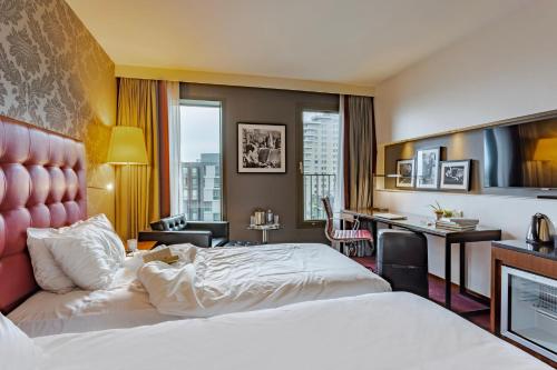 ein Hotelzimmer mit 2 Betten und einem Schreibtisch in der Unterkunft Crowne Plaza Amsterdam - South, an IHG Hotel in Amsterdam